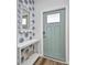 A welcoming hallway with blue accent wallpaper, console table and blue door at 900 E Marion Ave # 1203, Punta Gorda, FL 33950