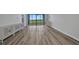 Bright living room featuring neutral walls, hardwood floors, and balcony access with green view at 900 E Marion Ave # 1203, Punta Gorda, FL 33950