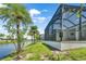 The backyard features a screened lanai, pond views, and lush palms at 10478 Coquina Ct, Placida, FL 33946