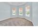 Bright bedroom with three large windows and plush carpeting at 10478 Coquina Ct, Placida, FL 33946