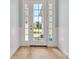 Bright entryway featuring a white front door with glass panels and wood-look flooring at 10478 Coquina Ct, Placida, FL 33946