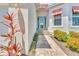 Close-up of the home's inviting entrance with well-maintained landscaping and a charming turquoise door at 10478 Coquina Ct, Placida, FL 33946