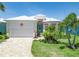 Charming single-story home showcasing a white metal roof, landscaped front yard, and two-car garage at 10478 Coquina Ct, Placida, FL 33946