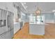Elegant kitchen with stainless steel refrigerator, white cabinetry, center island, and backyard views at 10478 Coquina Ct, Placida, FL 33946