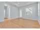 Open living room with wood-look floors, large windows, and neutral walls at 10478 Coquina Ct, Placida, FL 33946
