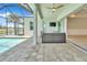 Covered lanai with brick pavers, ceiling fan, and comfortable seating area overlooking the pool at 10478 Coquina Ct, Placida, FL 33946