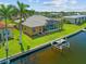 Aerial view of home's canal-front backyard with screened-in pool area and boat dock at 1323 Mineo Dr, Punta Gorda, FL 33950