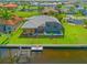 Aerial view of home's back exterior, screened pool, dock, and lush green backyard at 1323 Mineo Dr, Punta Gorda, FL 33950