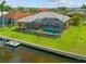 Aerial view of home's backyard, with screened-in pool area, canal, and lush landscaping at 1323 Mineo Dr, Punta Gorda, FL 33950