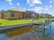 View of the house with a boat lift, screened-in lanai, and lush green backyard at 1323 Mineo Dr, Punta Gorda, FL 33950