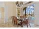 Elegant dining area with glass-top table, wicker chairs, chandelier, and views of the pool at 1323 Mineo Dr, Punta Gorda, FL 33950