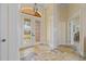Bright foyer featuring travertine flooring, decorative glass doors, and classic architectural details at 1323 Mineo Dr, Punta Gorda, FL 33950