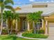 Inviting front entrance with lush landscaping, elegant columns, and a white-tiled roof at 1323 Mineo Dr, Punta Gorda, FL 33950