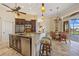 Open-concept kitchen with island, bar seating, and adjacent dining area with backyard pool view at 1323 Mineo Dr, Punta Gorda, FL 33950
