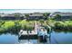 Waterfront property showcasing a private dock with a boat lift, chairs, landscaping, and scenic views of the surrounding waterways at 14436 Ponce De Leon Trl, Port Charlotte, FL 33981