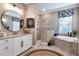 Bathroom features a double sink vanity, soaking tub, walk-in shower, and elegant fixtures at 14436 Ponce De Leon Trl, Port Charlotte, FL 33981