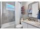 Bathroom with grey tiled walls, a white shower curtain, and granite countertops at 14436 Ponce De Leon Trl, Port Charlotte, FL 33981