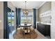 Bright dining room features a round table, chandelier, and sliding glass doors to the pool area at 14436 Ponce De Leon Trl, Port Charlotte, FL 33981