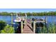 Private dock includes a boat lift for easy boat storage, along with relaxing waterfront seating overlooking the tranquil water views at 14436 Ponce De Leon Trl, Port Charlotte, FL 33981