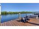 Enjoy serene water views from the wooden dock furnished with Adirondack chairs, ideal for relaxation and outdoor entertainment at 14436 Ponce De Leon Trl, Port Charlotte, FL 33981
