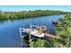 A boat with a lift system is parked on a private dock on a serene waterfront at 14436 Ponce De Leon Trl, Port Charlotte, FL 33981