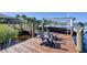 Waterfront home featuring a private wooden dock with seating, a boat lift and direct access to the water at 14436 Ponce De Leon Trl, Port Charlotte, FL 33981
