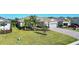 Beautiful single-story home featuring a well manicured lawn, tropical landscaping, and a brick paver driveway at 14436 Ponce De Leon Trl, Port Charlotte, FL 33981