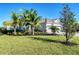 Inviting one-story home enhanced by mature palm trees, well-manicured lawn and a convenient two-car garage at 14436 Ponce De Leon Trl, Port Charlotte, FL 33981