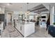 Open kitchen and living space with white cabinets, stainless appliances, and wood-look tile floors at 14436 Ponce De Leon Trl, Port Charlotte, FL 33981