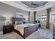 Spacious main bedroom with tray ceilings, a ceiling fan, and windows overlooking the backyard at 14436 Ponce De Leon Trl, Port Charlotte, FL 33981