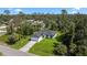 Aerial view of a modern home with a well-manicured lawn nestled among lush trees at 17156 Eugene Ave, Port Charlotte, FL 33954