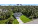 Aerial view of a modern home with a well-manicured lawn nestled among lush trees at 17156 Eugene Ave, Port Charlotte, FL 33954