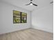 Bright bedroom with ceiling fan and window showing landscaped outdoor view at 17156 Eugene Ave, Port Charlotte, FL 33954
