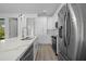Modern kitchen featuring pendant lighting, white cabinetry, stainless steel appliances, and wood-look flooring at 17156 Eugene Ave, Port Charlotte, FL 33954