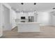 Well-lit kitchen boasting pendant lights, white cabinetry, stainless steel appliances, and wood-look flooring at 17156 Eugene Ave, Port Charlotte, FL 33954