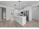 Contemporary kitchen featuring pendant lighting, white cabinetry, stainless steel appliances, and wood-look flooring at 17156 Eugene Ave, Port Charlotte, FL 33954