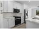 Modern kitchen featuring white cabinets, stainless steel appliances, and marble countertops at 17156 Eugene Ave, Port Charlotte, FL 33954