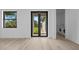 Bright living room featuring wood-look flooring, a double door, a window, and a glimpse of the laundry area at 17156 Eugene Ave, Port Charlotte, FL 33954
