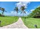 A paver walkway leads to a private dock with scenic water views in this lush backyard at 17509 Ohara Dr, Port Charlotte, FL 33948