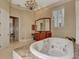 Lavish bathroom with a jacuzzi tub, granite counters, and wood cabinets at 17509 Ohara Dr, Port Charlotte, FL 33948