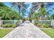 Long driveway leading to an exquisite home, framed by mature palms and a gated entrance at 17509 Ohara Dr, Port Charlotte, FL 33948