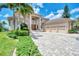 Elegant home featuring a three-car garage, manicured landscaping, and paver driveway at 17509 Ohara Dr, Port Charlotte, FL 33948