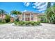 Elegant home with a circular driveway, fountain, manicured landscaping, and grand entrance, radiating curb appeal at 17509 Ohara Dr, Port Charlotte, FL 33948