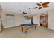 Spacious game room with a pool table, carpeted floors, a wet bar, and three ceiling fans at 17509 Ohara Dr, Port Charlotte, FL 33948