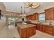 An open kitchen boasts wood cabinets, granite countertops, an island, and views of the living area and water at 17509 Ohara Dr, Port Charlotte, FL 33948