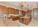 Gourmet kitchen featuring custom wood cabinetry, granite countertops, an island with a wine cooler, and modern appliances at 17509 Ohara Dr, Port Charlotte, FL 33948