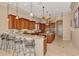 Gourmet kitchen with custom wood cabinetry, bar seating, granite countertops, stainless steel appliances, and large central island at 17509 Ohara Dr, Port Charlotte, FL 33948