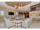 Open-concept living room showcasing a sleek entertainment center, comfortable seating, and natural light, complemented by views of the kitchen at 17509 Ohara Dr, Port Charlotte, FL 33948
