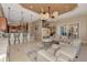 Expansive living room featuring a large white sectional, stone fireplace and seamless access to the kitchen and outdoor spaces at 17509 Ohara Dr, Port Charlotte, FL 33948