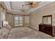 The main bedroom is bright with tray ceilings, plush carpet, and water views at 17509 Ohara Dr, Port Charlotte, FL 33948